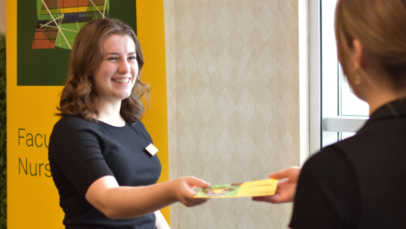 University counsellor handing out information at a nursing event