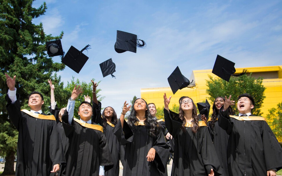 Grad students throwing their hats up in the air. 