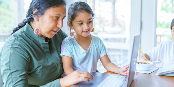 Woman and child sitting together using a laptop