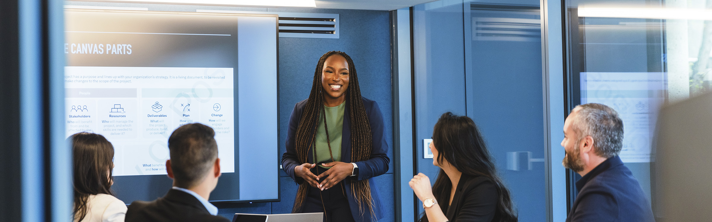 A student smiles to her audience while delivering a presentation