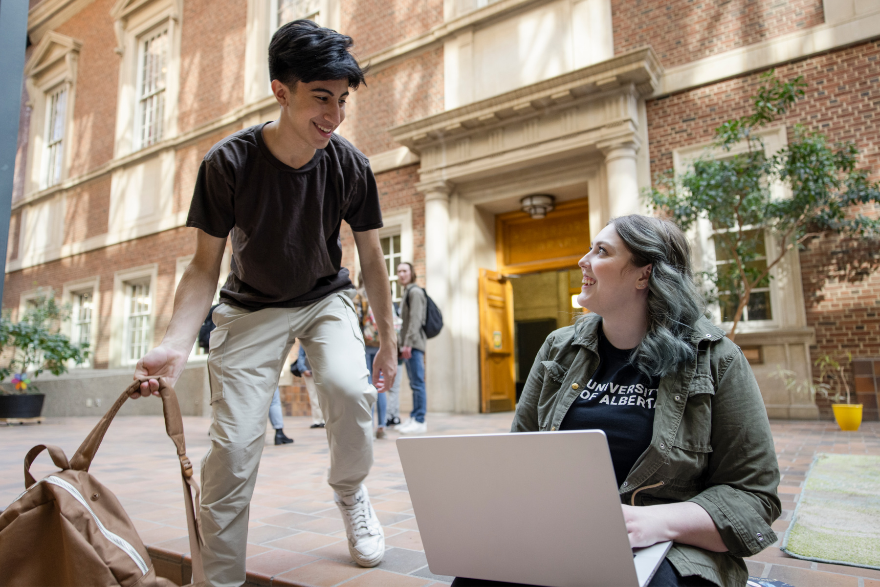 2 Students sitting in front of Rutherford Library