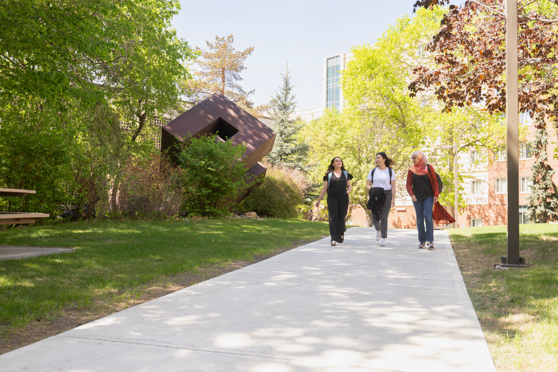 A group of students walking outdoors by the Education Cube