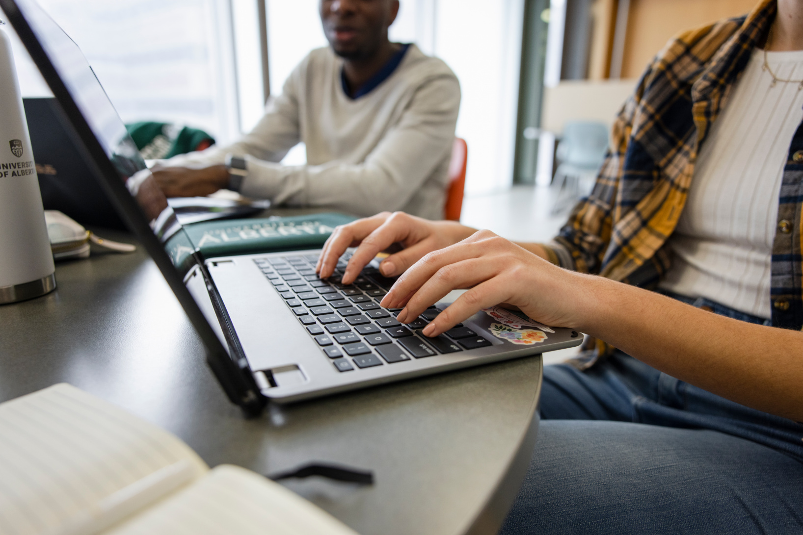 Hands typing on a laptop