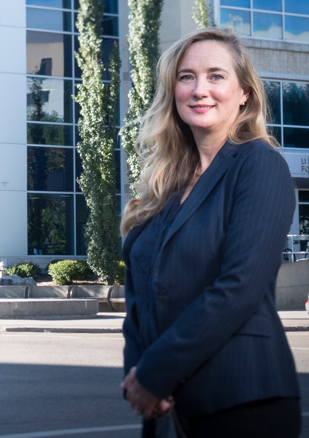 Joanne Lemieux stands in front of the Katz Group Centre for Pharmacy and Health Research, home to the Li Ka Shing Institute of Virology at the U of A. (Photo: John Ulan)