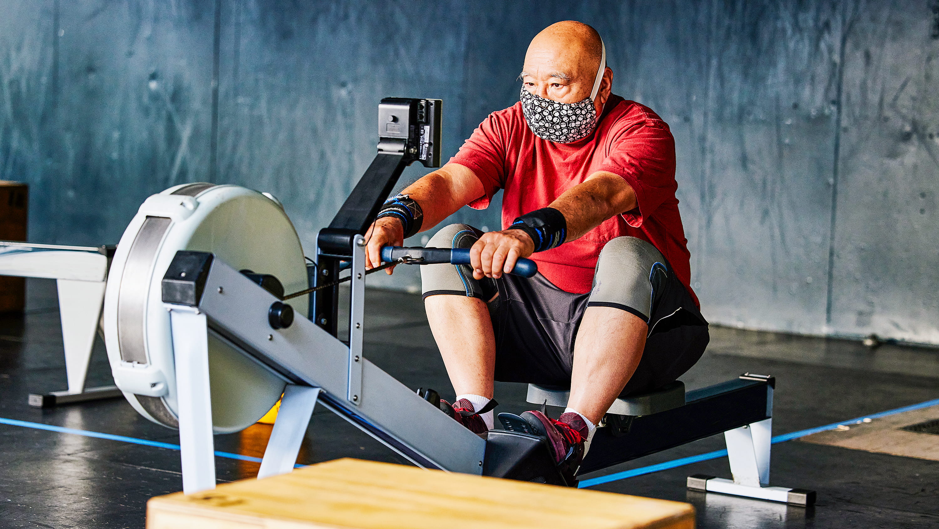 Masked man works out on rowing machine. (Photo: Getty Images)