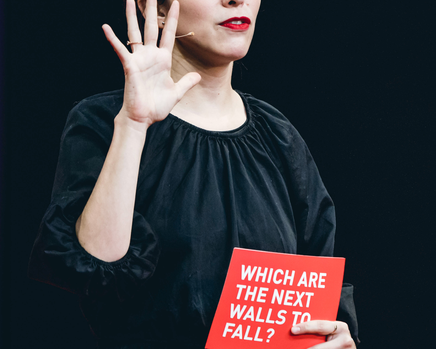 Woman holding up hand and talking into mic