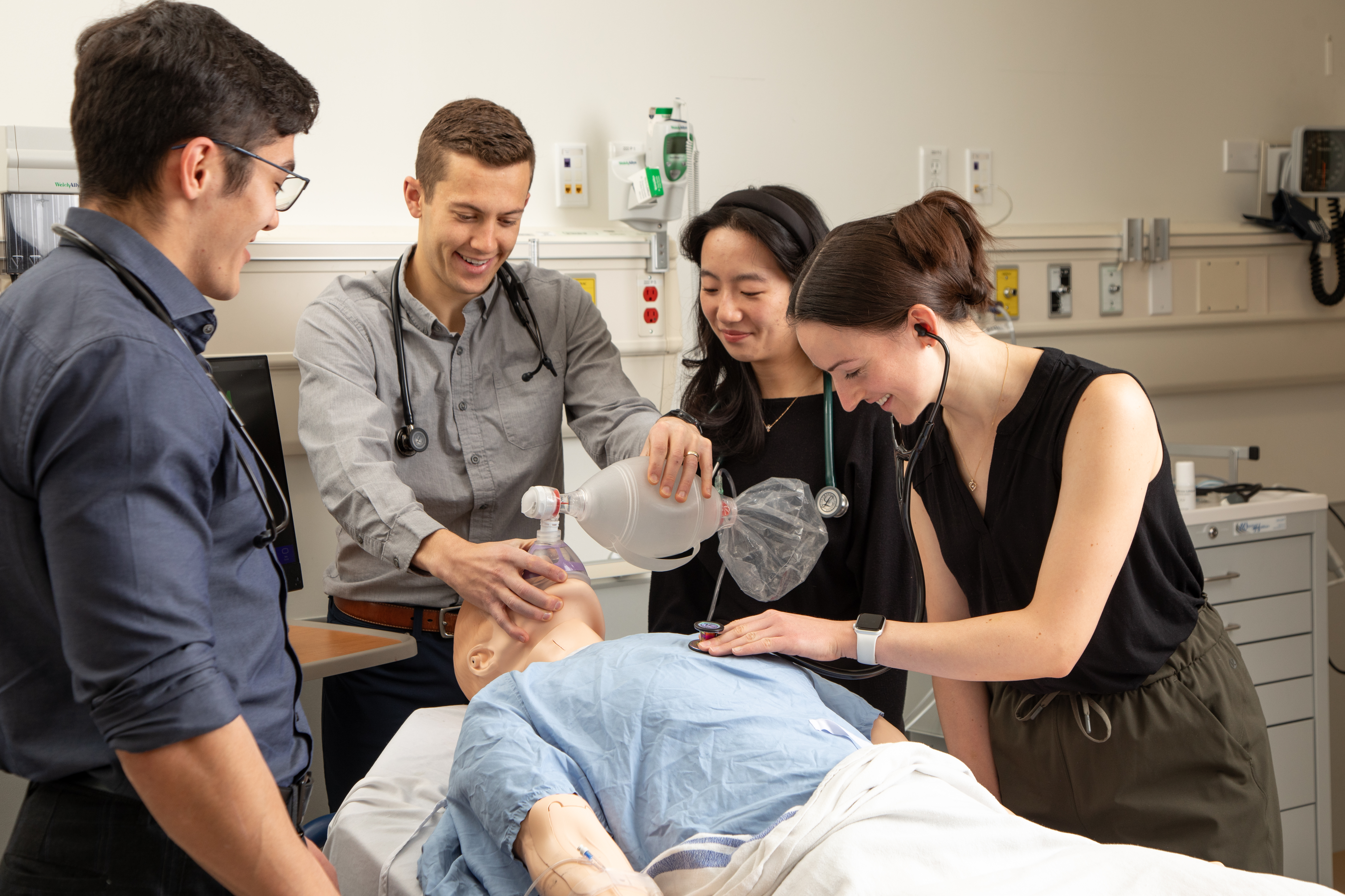 Medical students practicing respiratory procedure on a medical replica of a patient