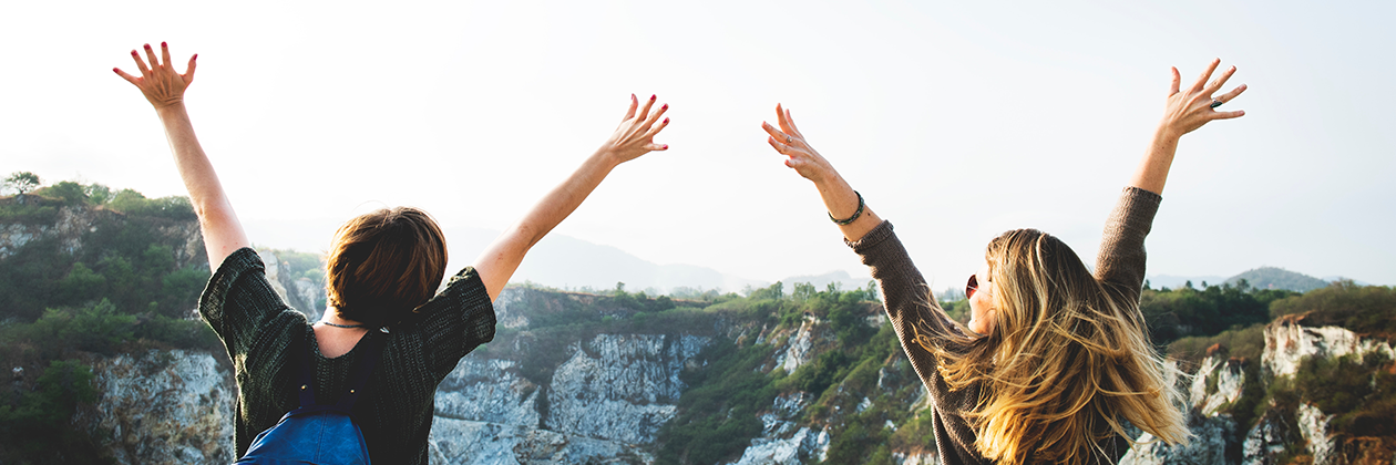 two people outside with hands raised in the air