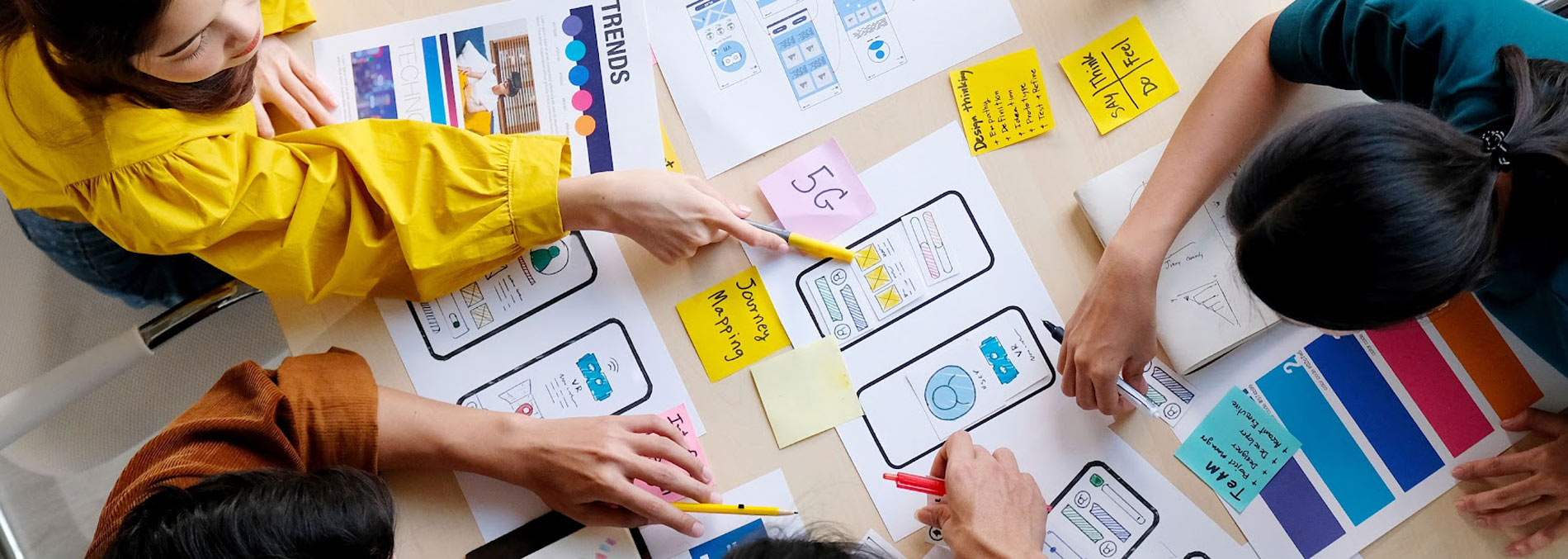 Three people working through a project across a table