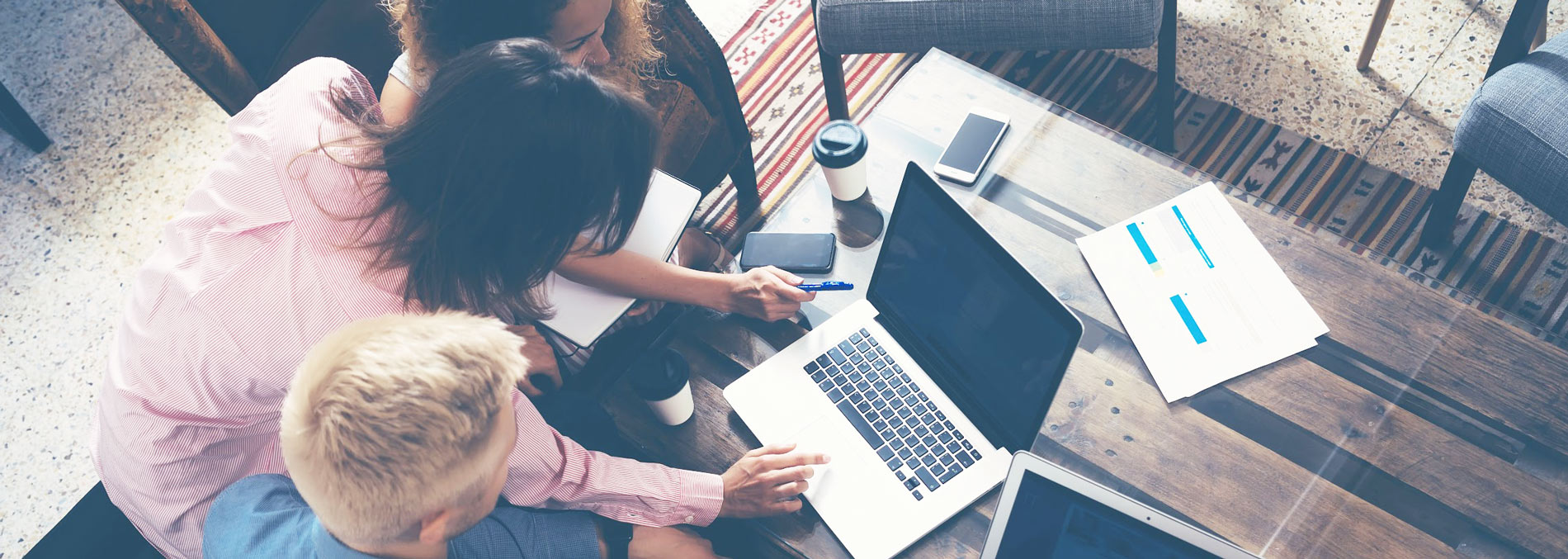 Group of people working around a computer