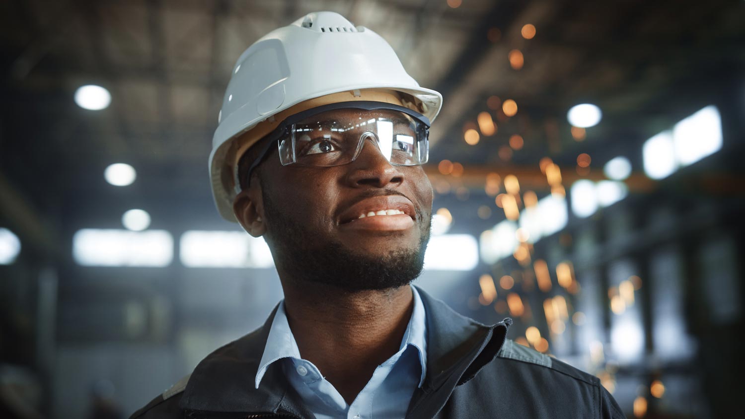 Man wearing a hard hat smiling in satisfaction