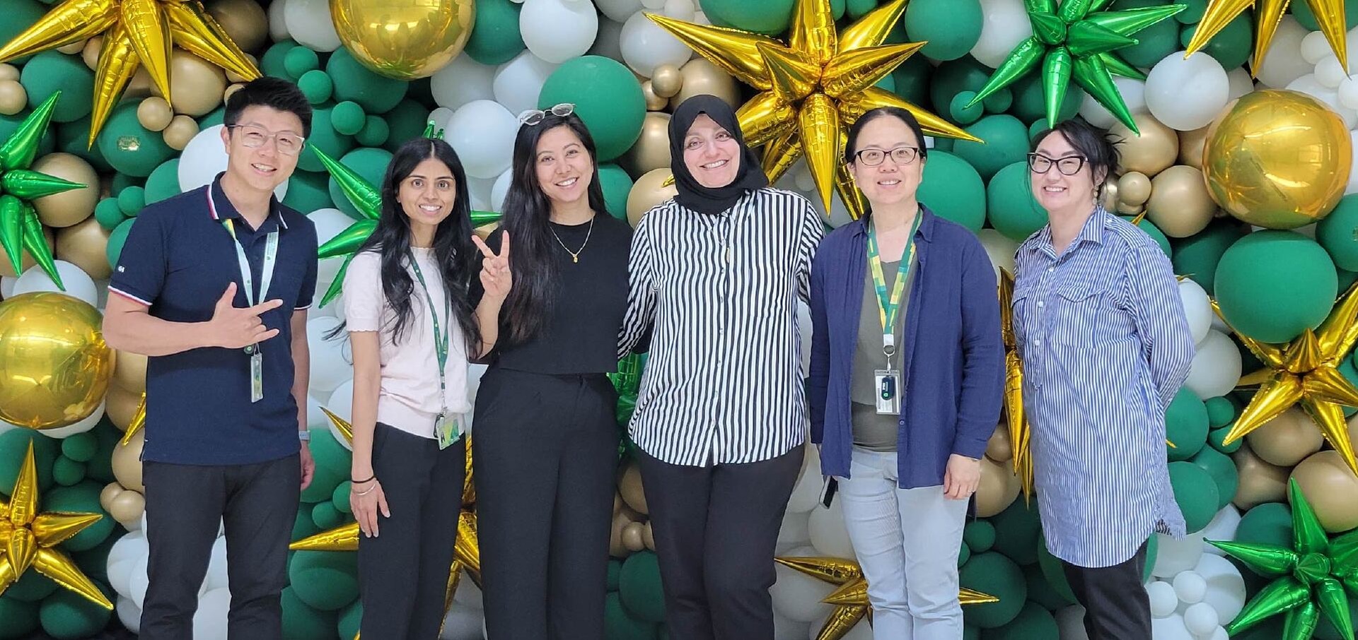 Students pose in front a balloon background at ISVS event.