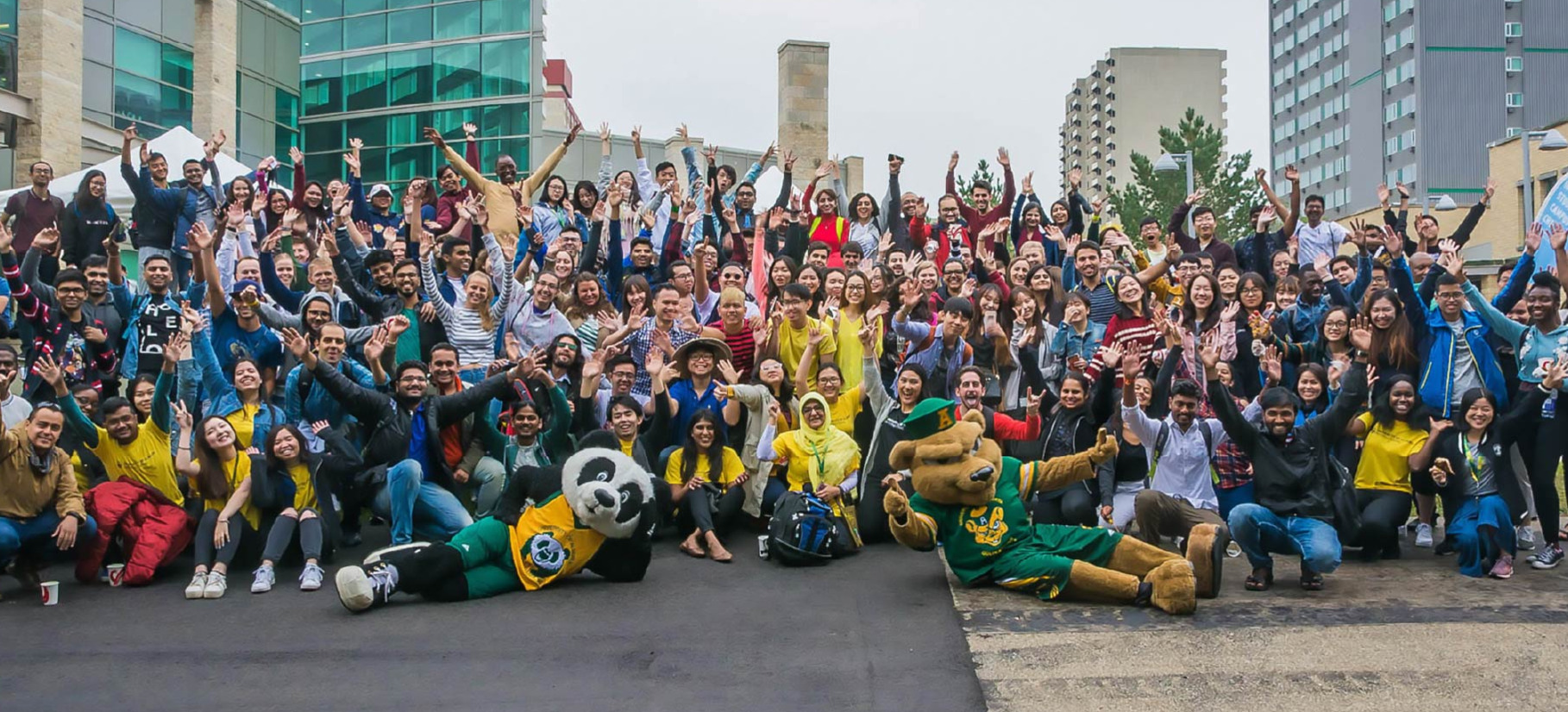 Student pose in a group photo with Guba and Patches outside TELUS Centre.