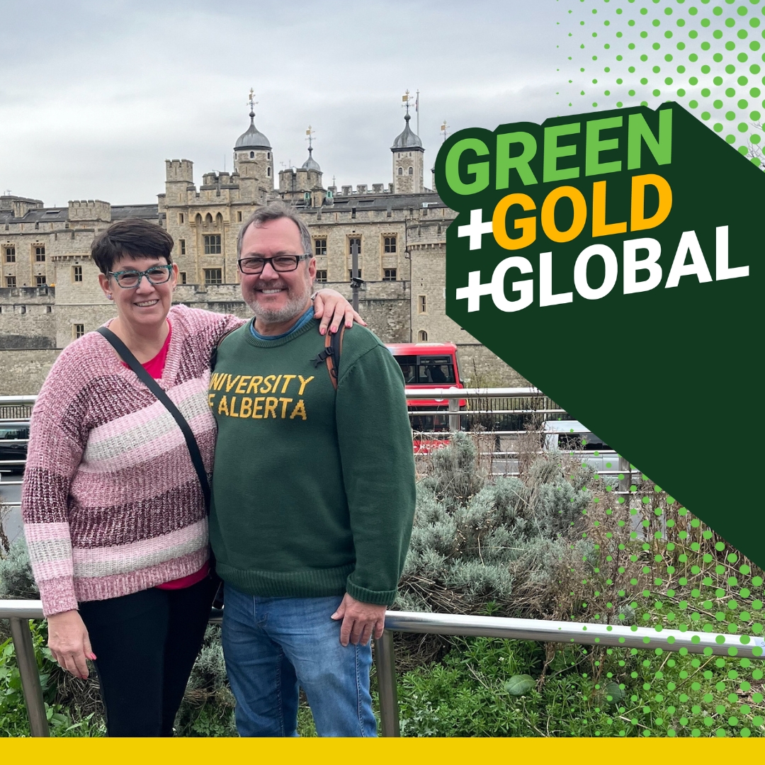 A woman has her arm over the shoulder of a man wearing a University of Alberta green sweatshirt with a red double decker bus in the background for Green and Gold and Global.