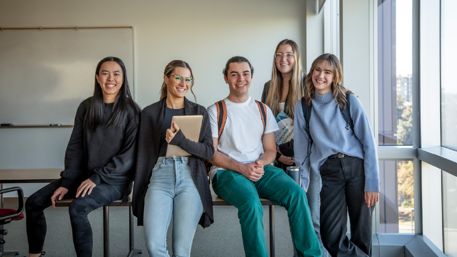 Group of students inside smiling for the camera