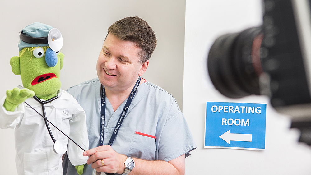 Jon white works with licensed Muppet Dr. Scalpel during Surgery 101 video recording.