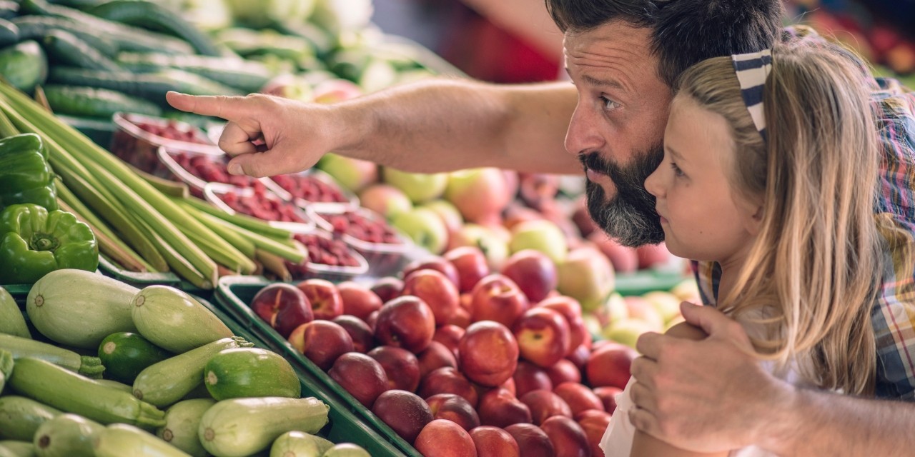 Father and daughter looking at fresh produce