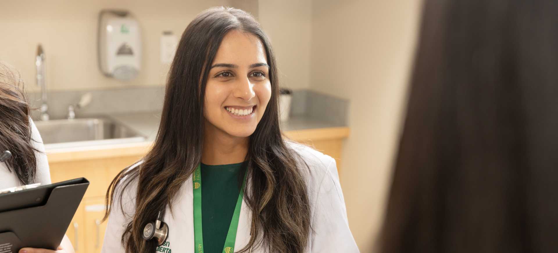 Woman in white lab coat smiling