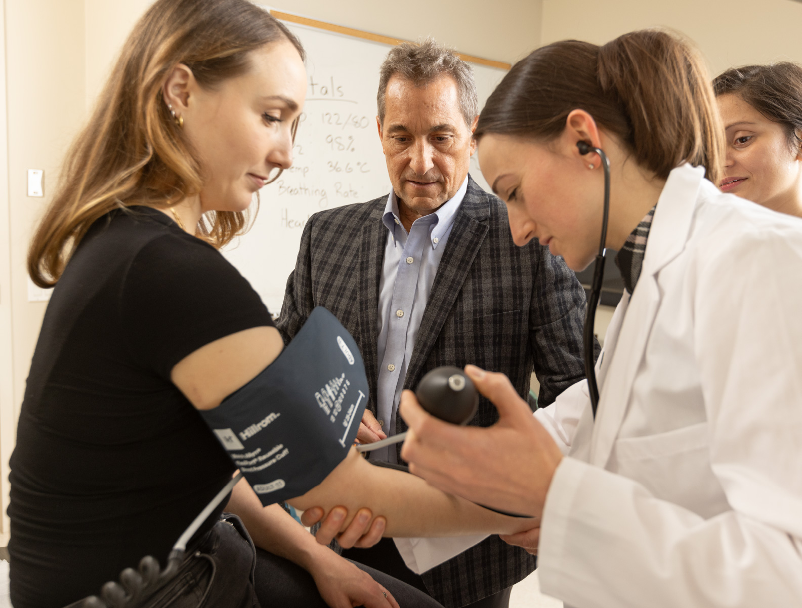 A medical student practicing examining a patient