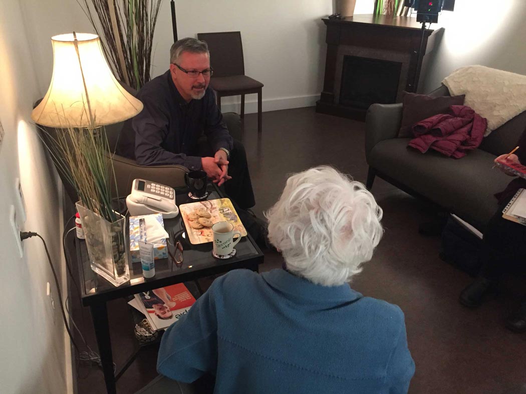 Behind the scenes of the EFS video shoot, an older woman is seen from behind talking with a man