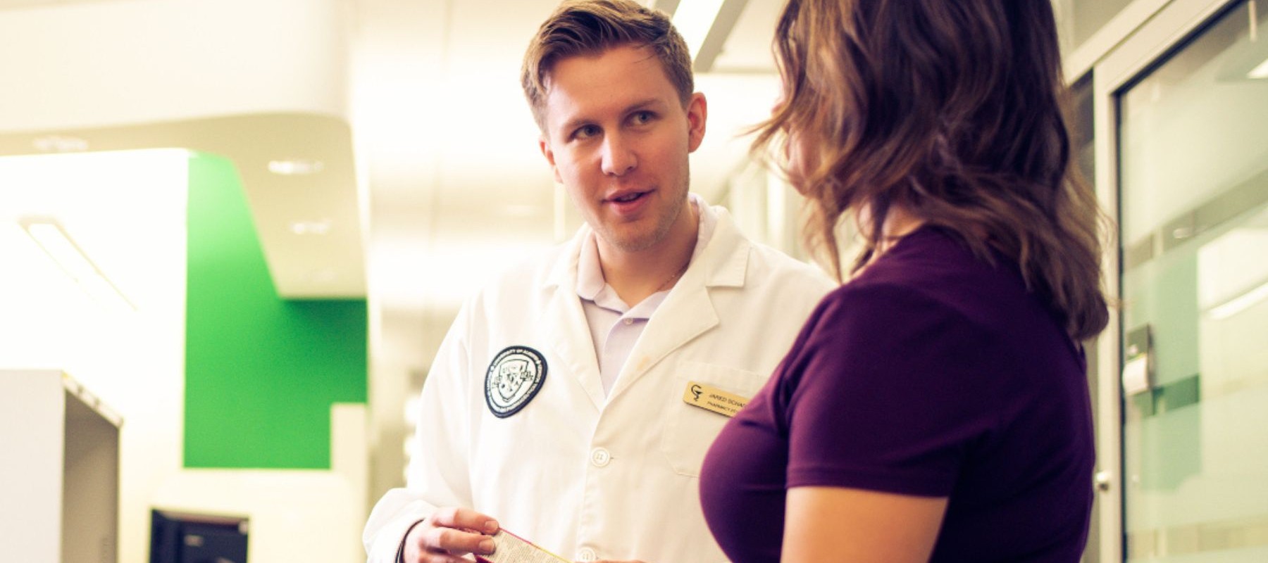 Pharmacists talking to woman